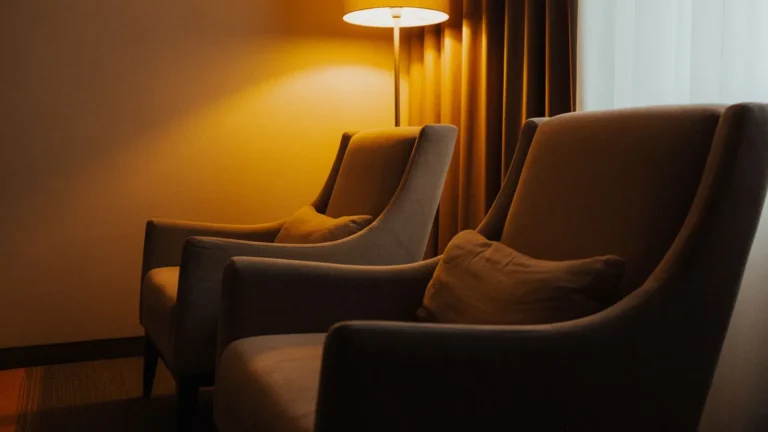 Pair of soft lounge chairs beneath a warm floor lamp