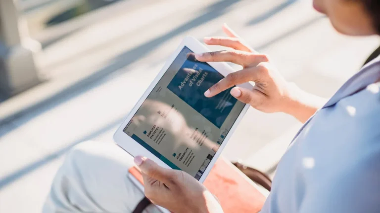 Woman browsing search results on a tablet outdoors in soft natural light