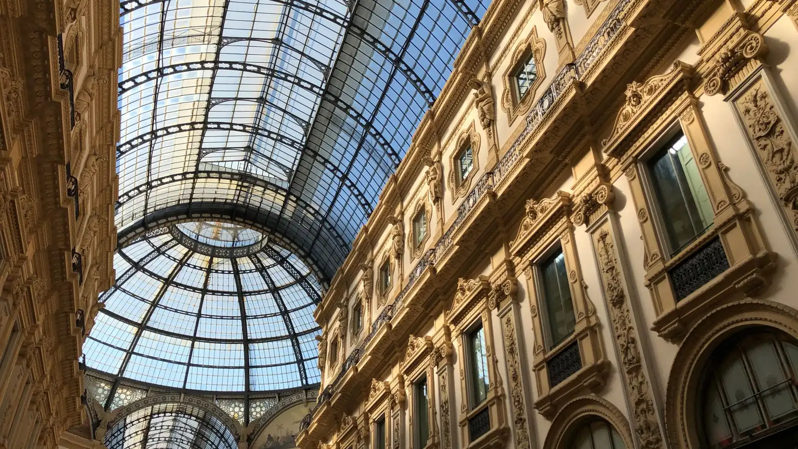 Glass-domed Italian gallery with ornate facades seen from below