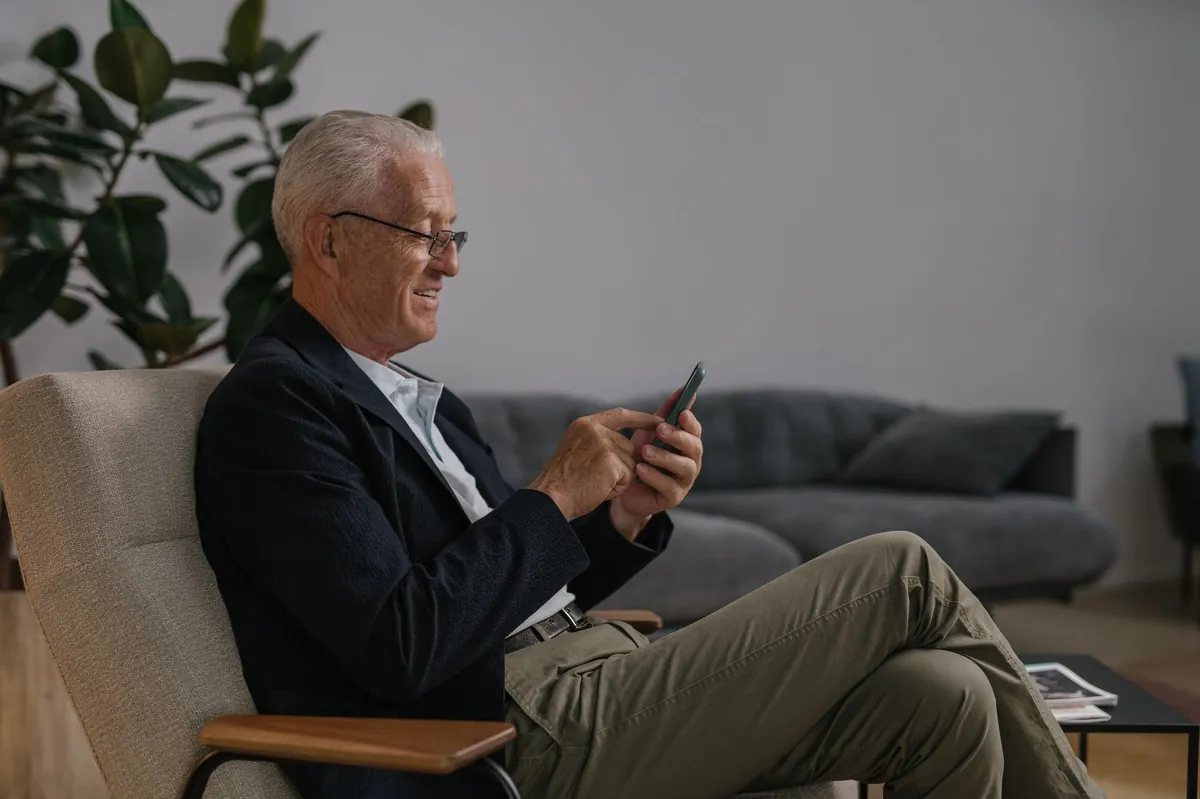 Mature professional in a suit checking his phone in a modern lounge