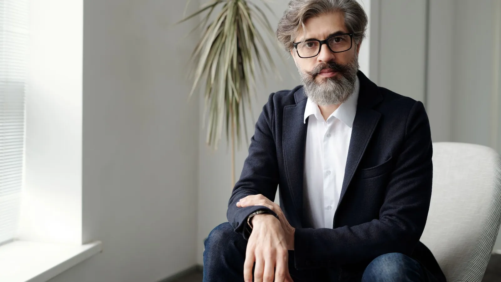 Practice owner in a suit seated in a bright office, ready to discuss AI search visibility