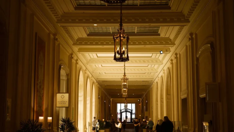 Long gilded corridor lit by hanging bronze lanterns