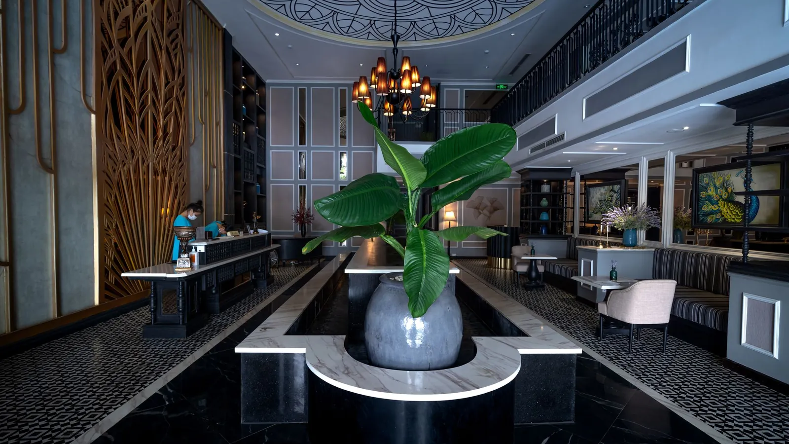 Luxury lobby with black marble floors, a reception desk and an orchid centerpiece
