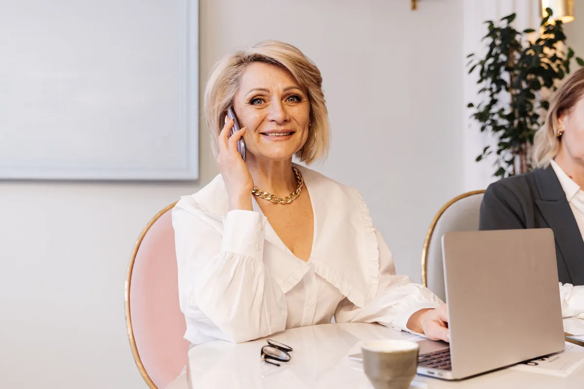 Smiling front office lead on the phone while working in a modern office