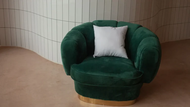 Green velvet armchair on a brass base in a calm, minimal room