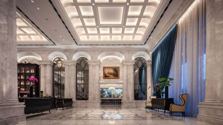 Marble lobby with a coffered ceiling, columns and navy drapes