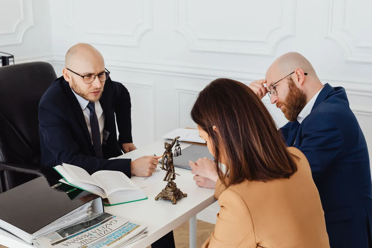 Advisor reviewing documents with a client across a desk in a white paneled office