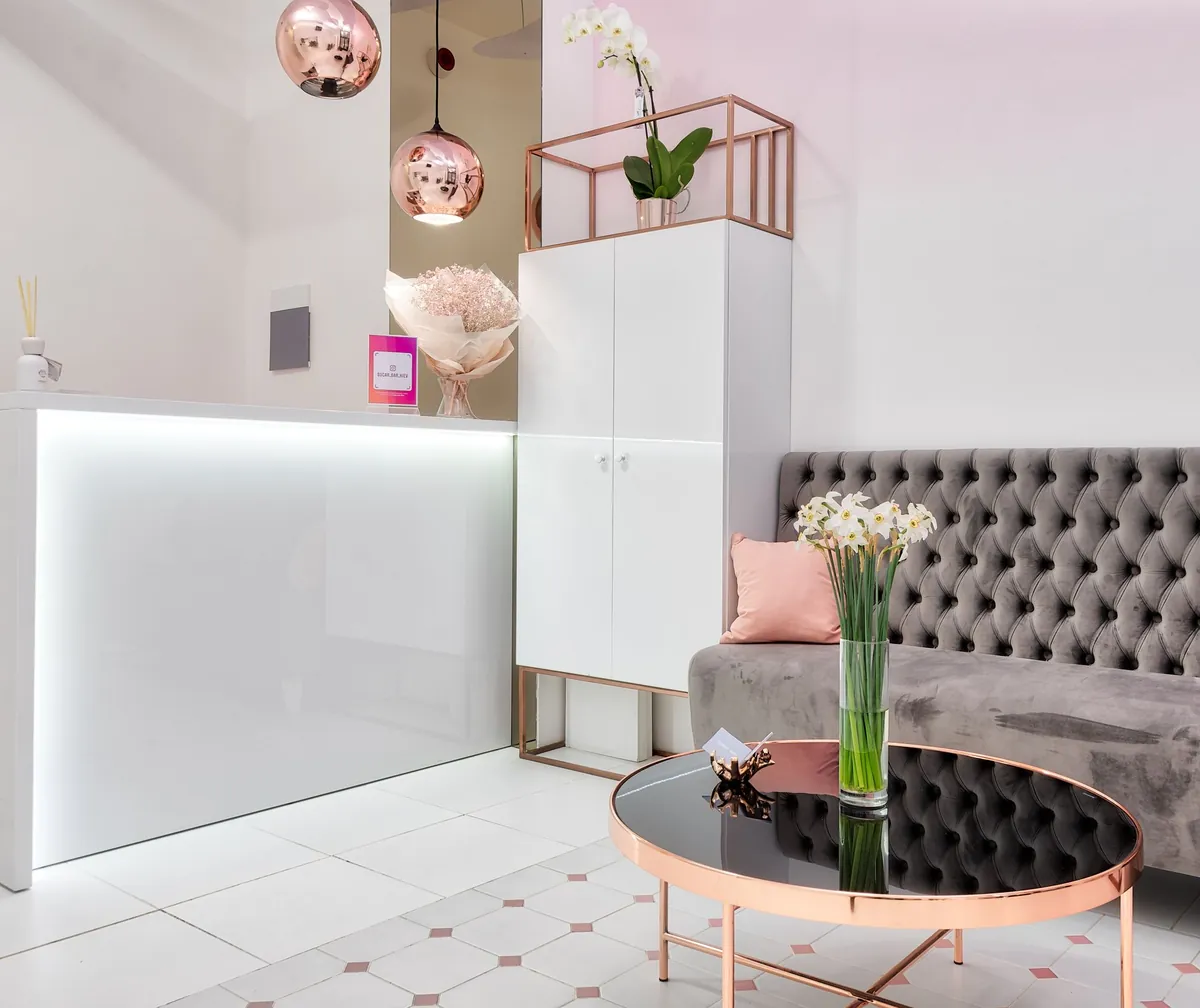 Luxe blush reception with a tufted velvet sofa and fresh florals