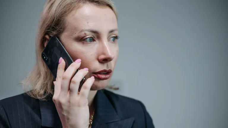 Professional in corporate attire taking a call at her desk