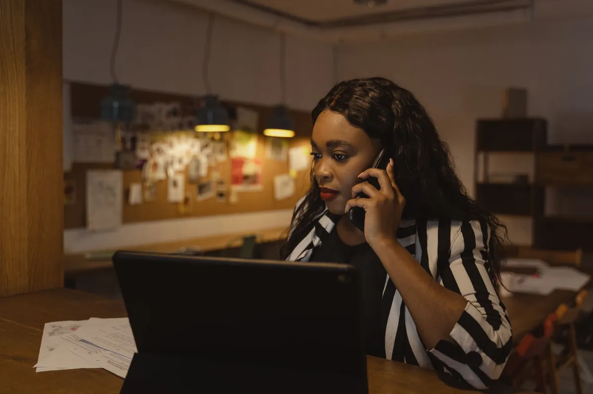 Professional in a striped blazer making a phone call in a modern office