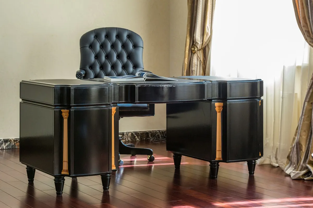 Black lacquered executive desk with a tufted leather chair