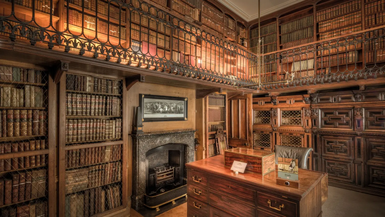 Two-story library with dark wood shelving and a reading desk