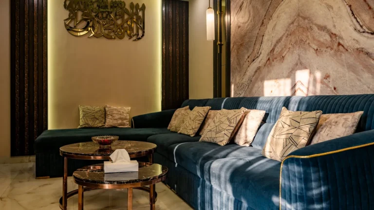 Boutique lounge with a navy velvet sofa, a marble feature wall and brass accents