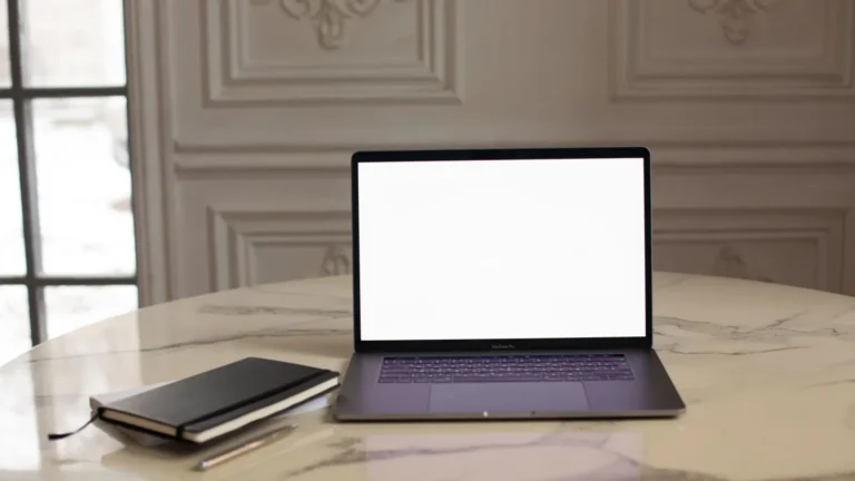 Laptop on a marble table in a paneled room, ready for a review of practice website content
