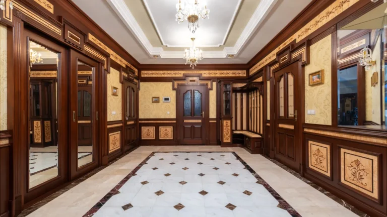 Wood-paneled hallway with a marble inlay floor and a small crystal chandelier