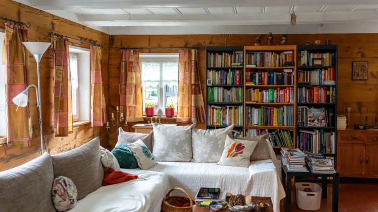 Cozy reading room with tall bookshelves, a linen sofa and patterned cushions