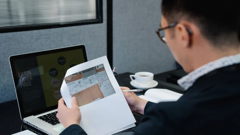 Practice owner analyzing search documents with a laptop open in an office