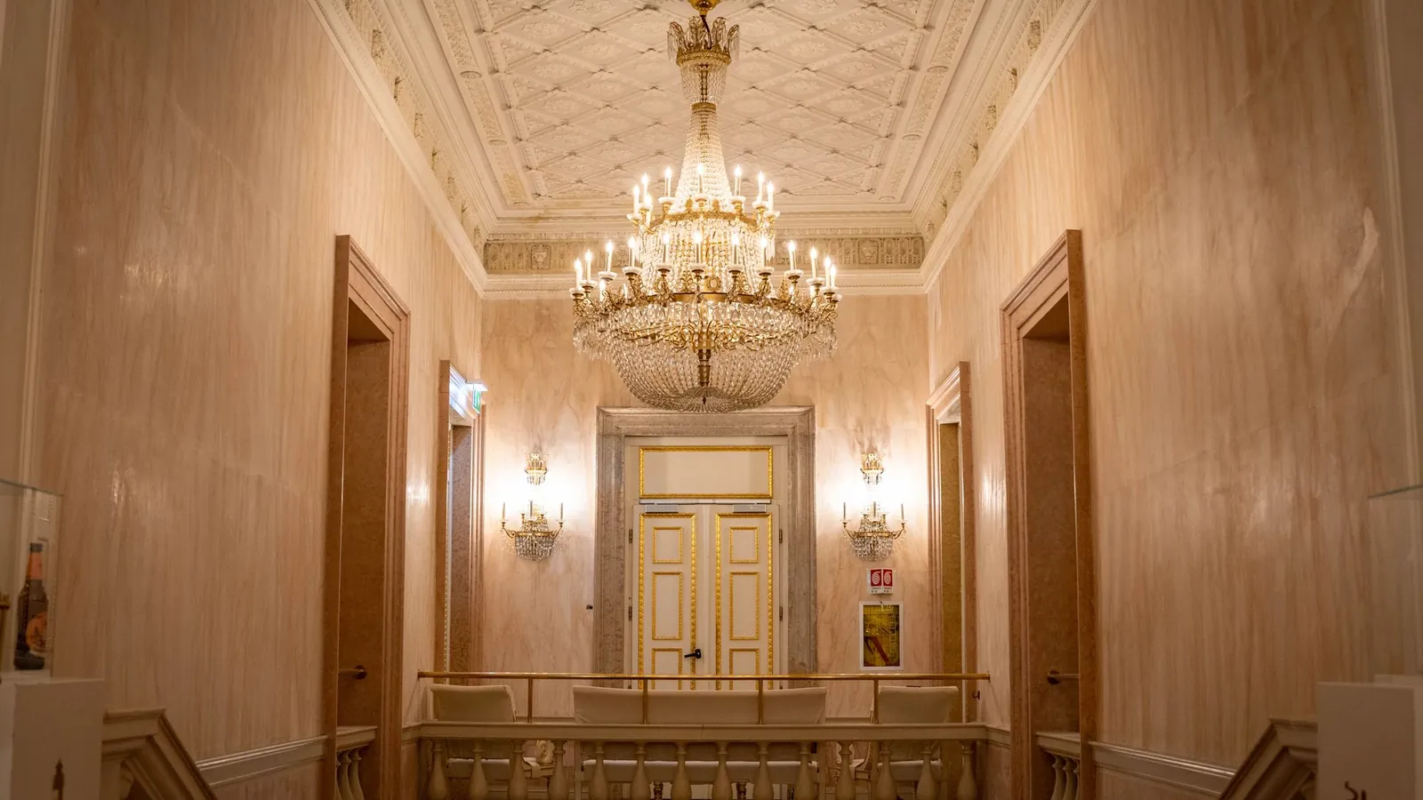 Paneled hall in warm cream with a tiered crystal chandelier