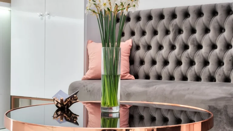 Tufted velvet sofa with white flowers and a rose gold table in a boutique lounge