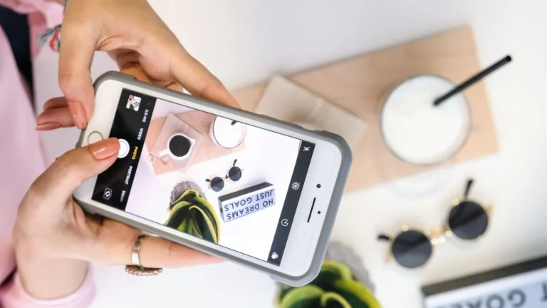 Content creator photographing a styled flat lay with a smartphone for social video