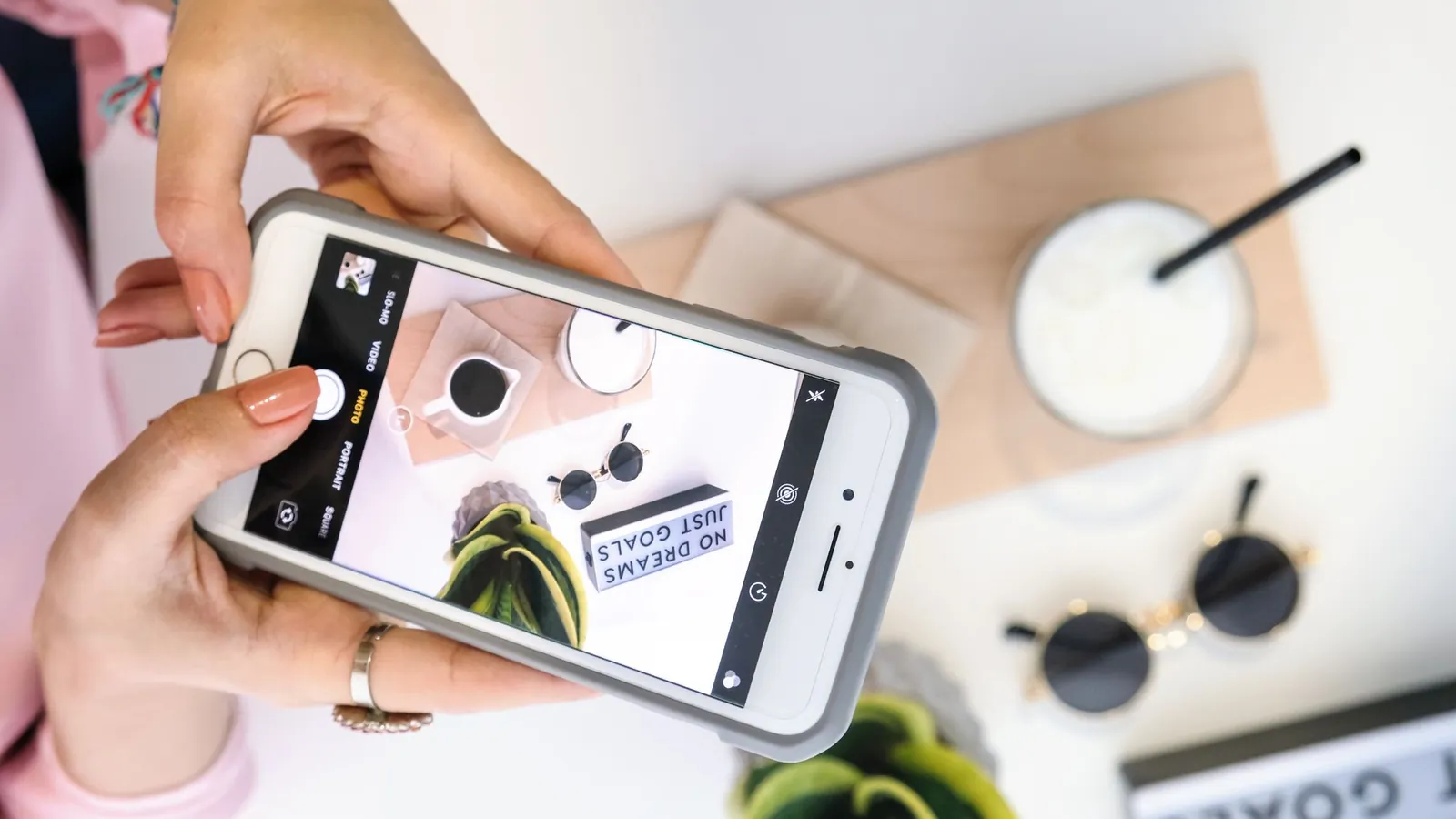 Content creator photographing a styled flat lay with a smartphone for social video