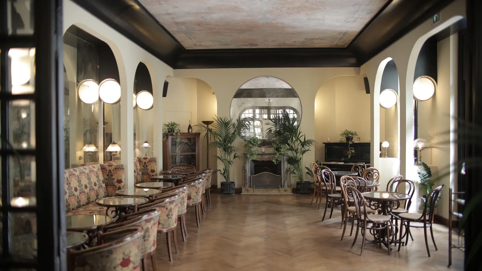 Art deco cafe with arched mirrors, globe sconces and bentwood chairs