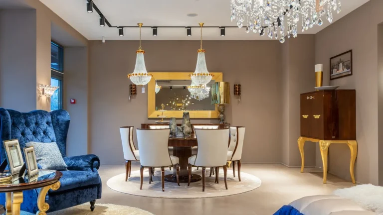 Dining room with a blue velvet armchair, a crystal chandelier and a gold console