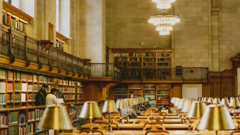 Grand reading room with brass desk lamps and long wooden tables