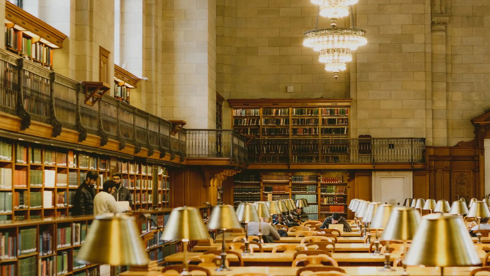 Grand reading room with brass desk lamps and long wooden tables