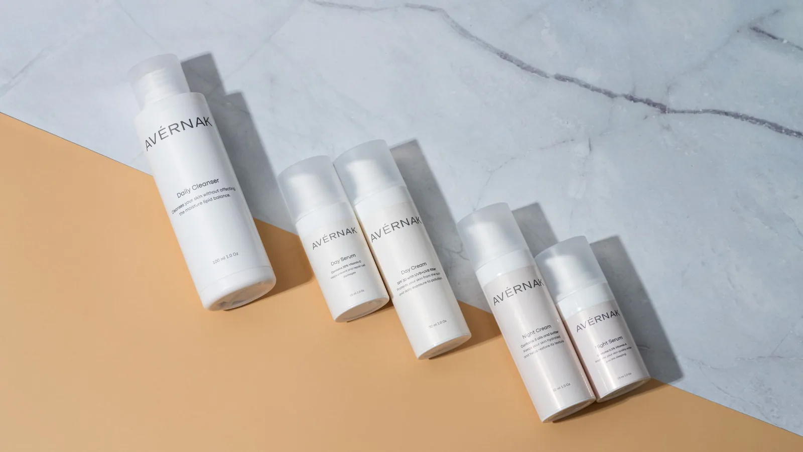 Skincare products arranged on marble and warm beige stone