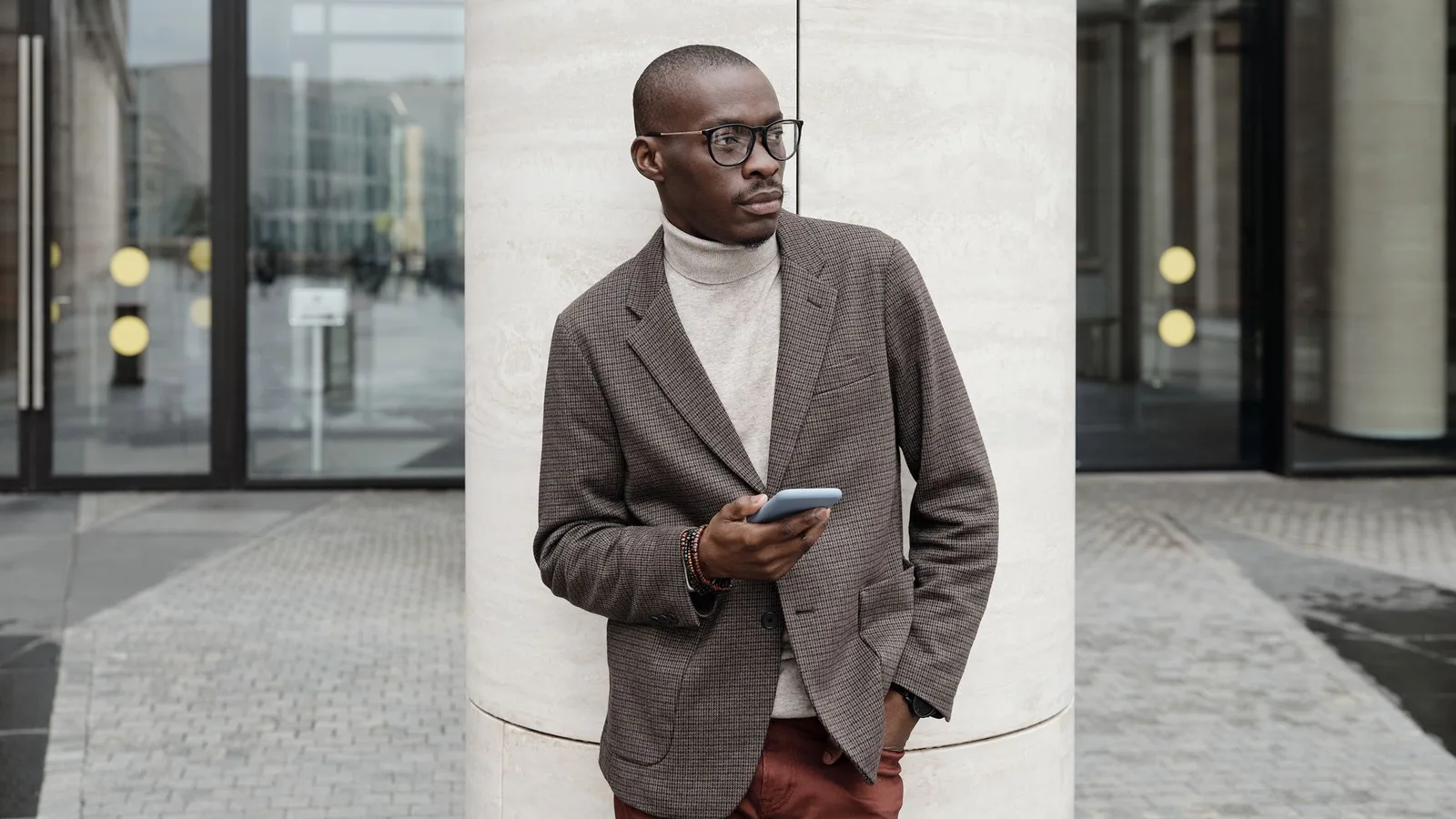 Professional in a tailored blazer reading a message on his iPhone