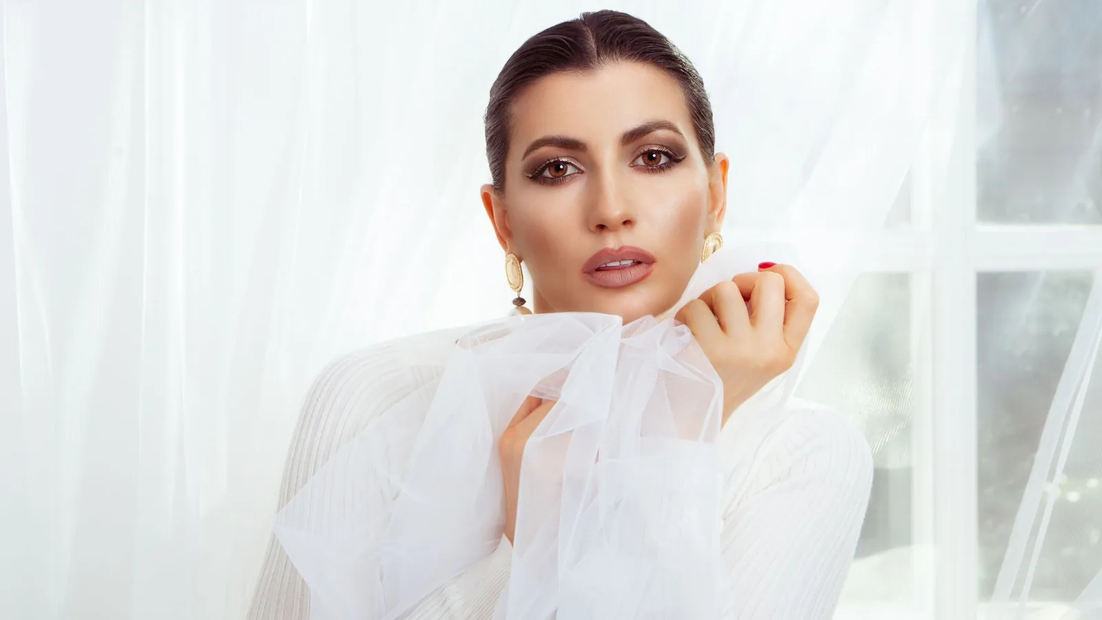 Elegant woman in a sheer white blouse in soft natural light