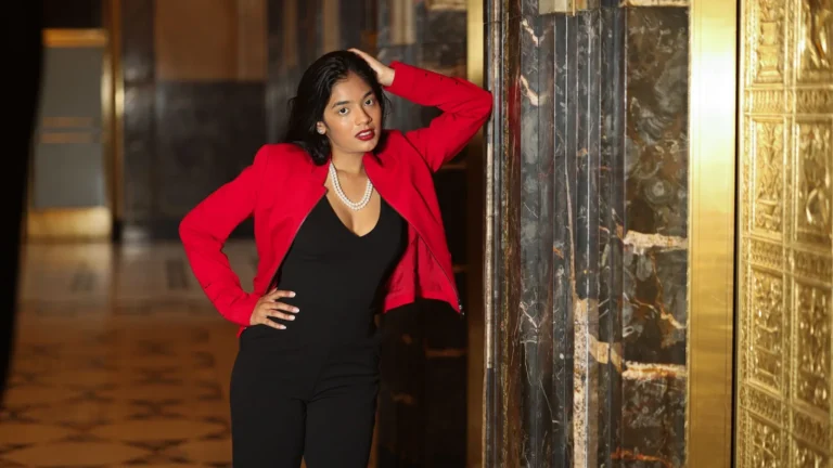 Owner in a red blazer in a luxurious marble and gold interior