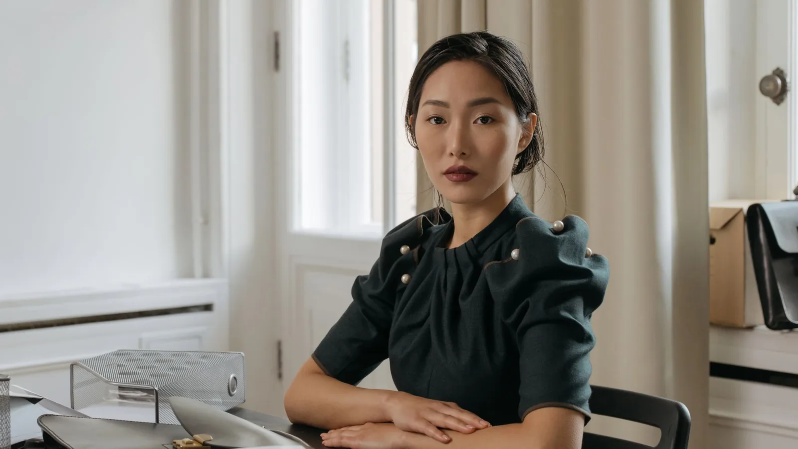 Practice owner seated at her desk in a calm, elegant office
