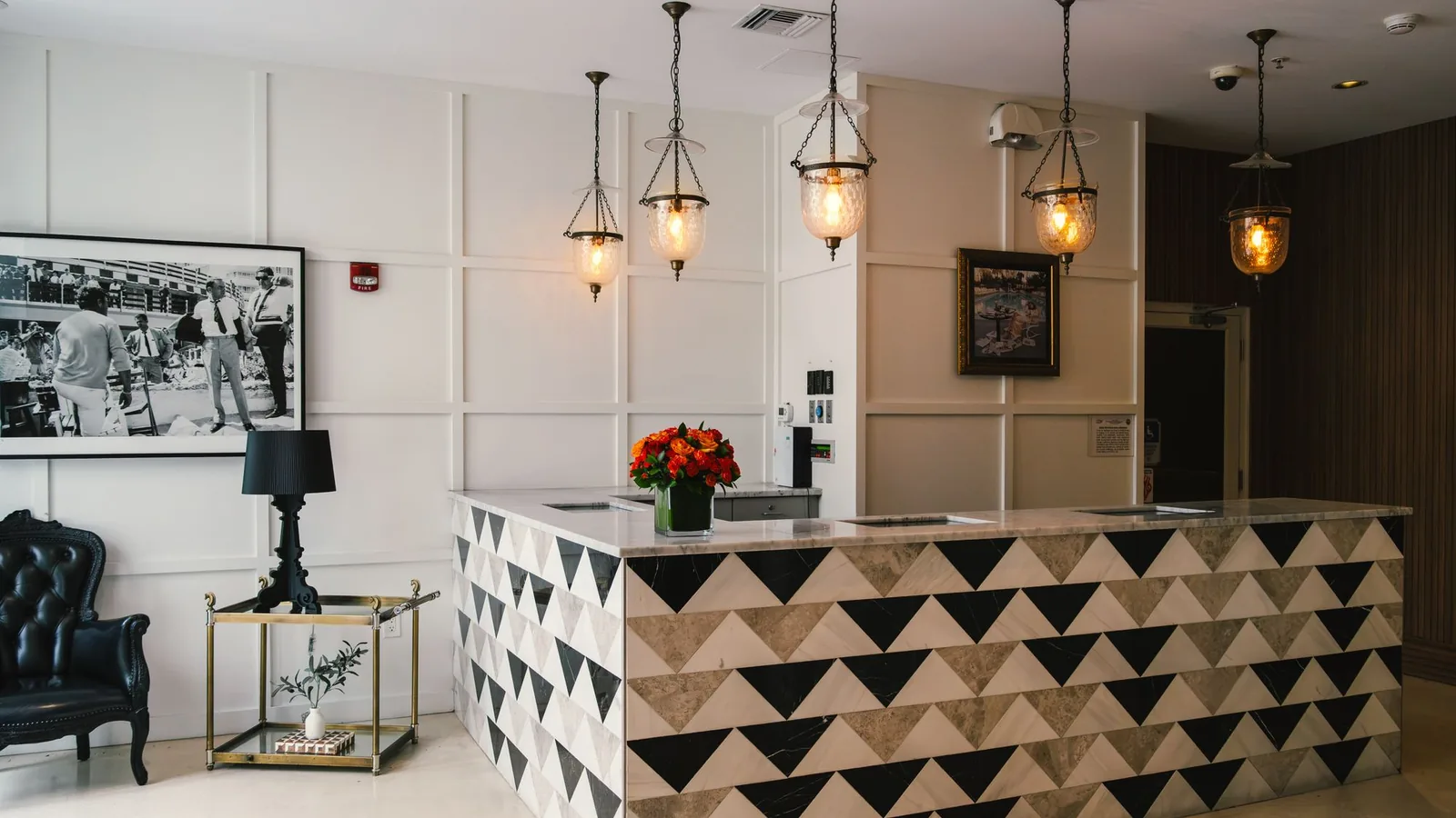 Elegant boutique reception with a patterned front desk and brass pendant lights