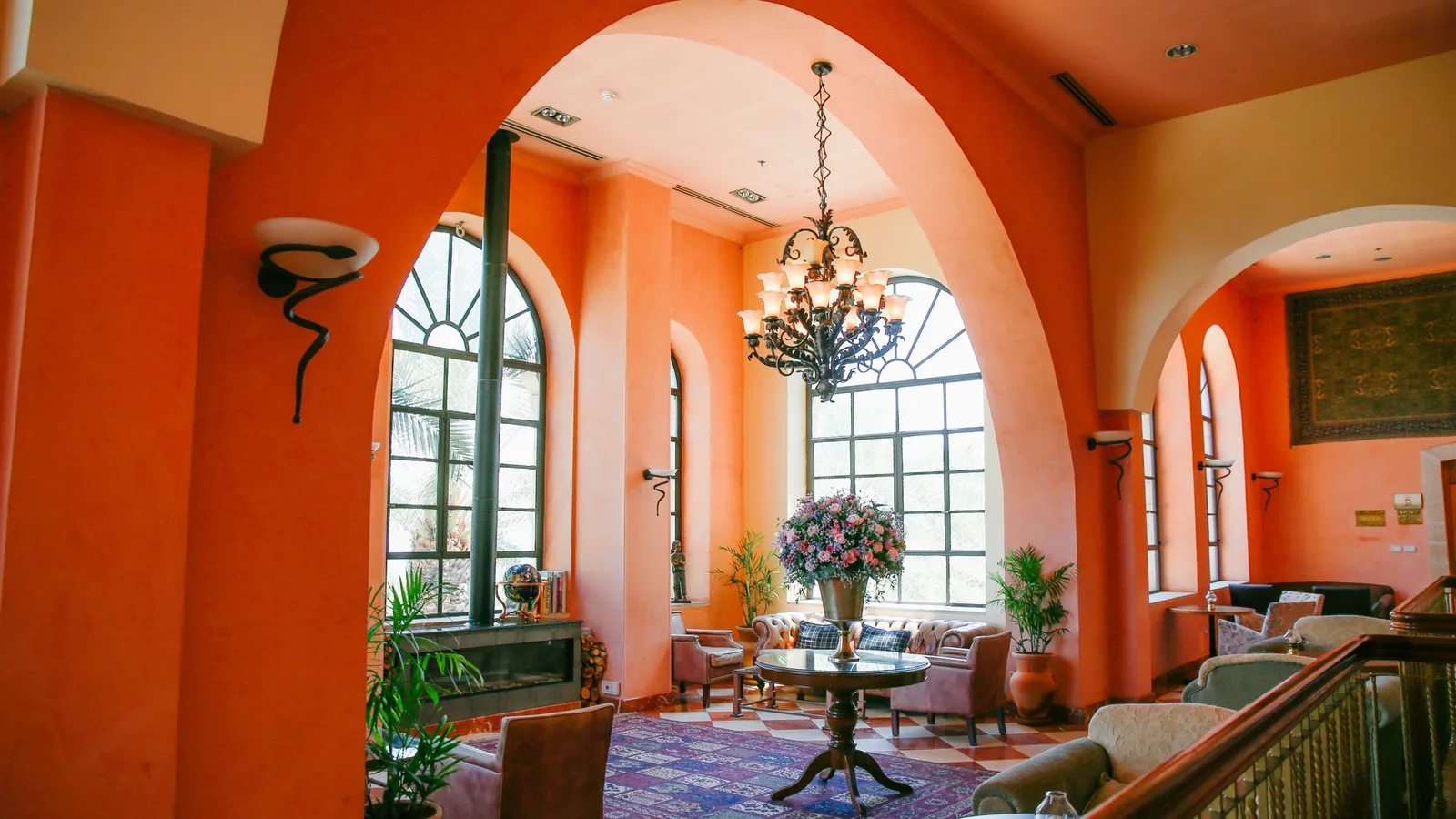 Mediterranean-style interior with arched windows, terracotta walls and greenery