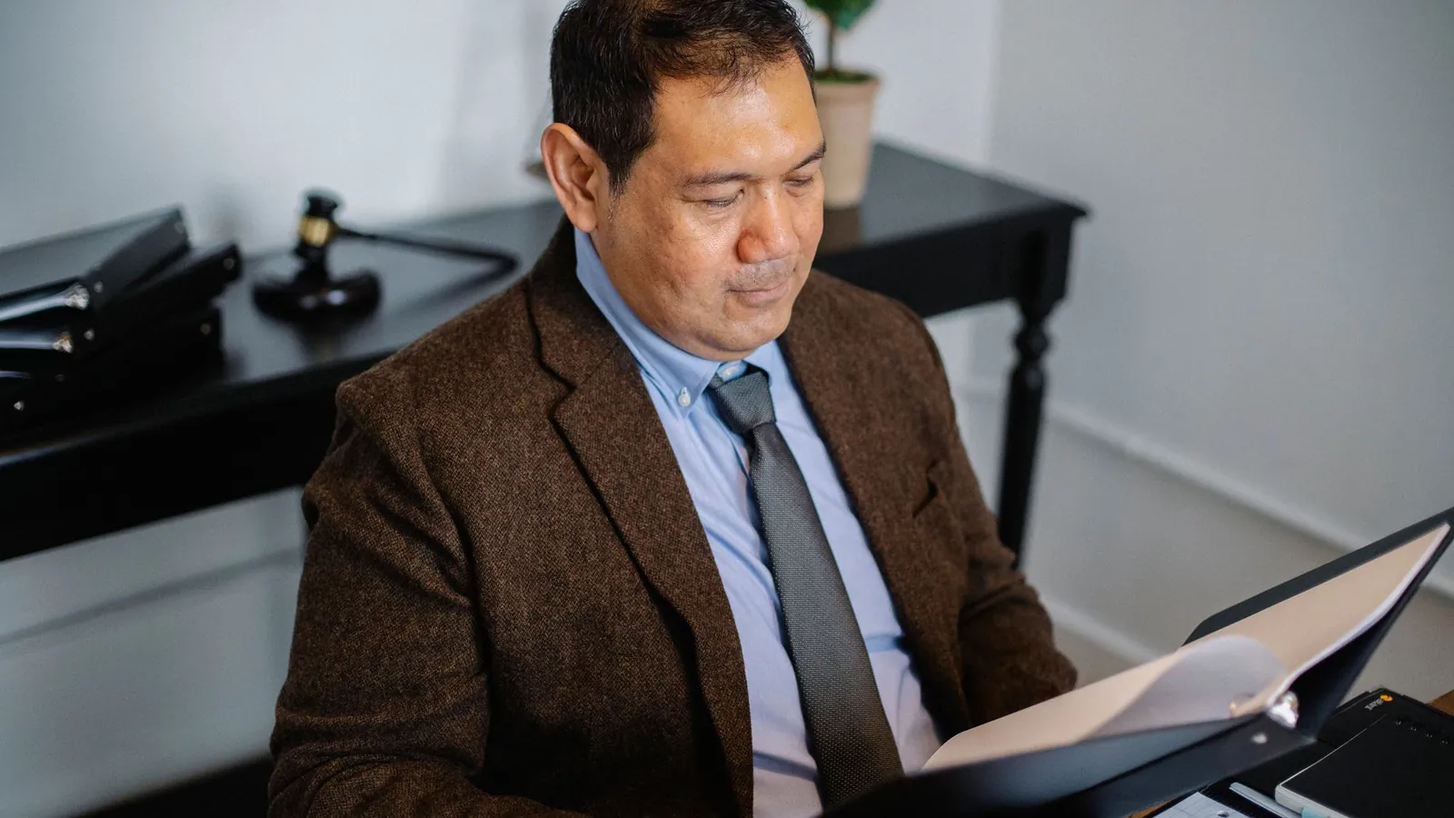 Advisor in a suit checking a report in a folder in an office