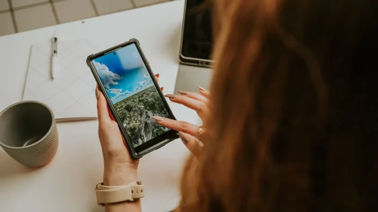 Close view of a smartphone in use at an office desk, checking social apps