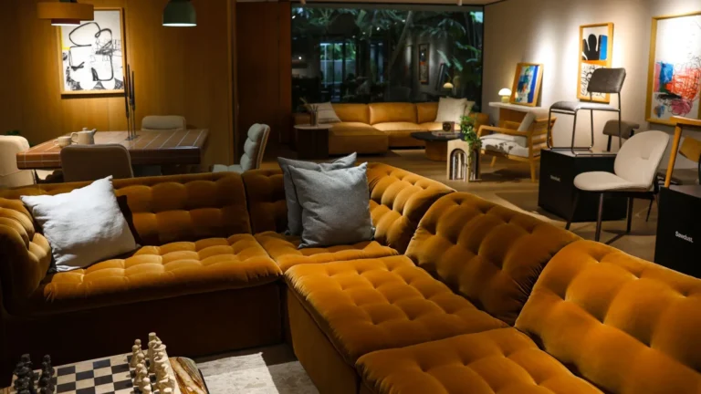 Lounge with a cognac velvet sectional, a chessboard and warm lighting