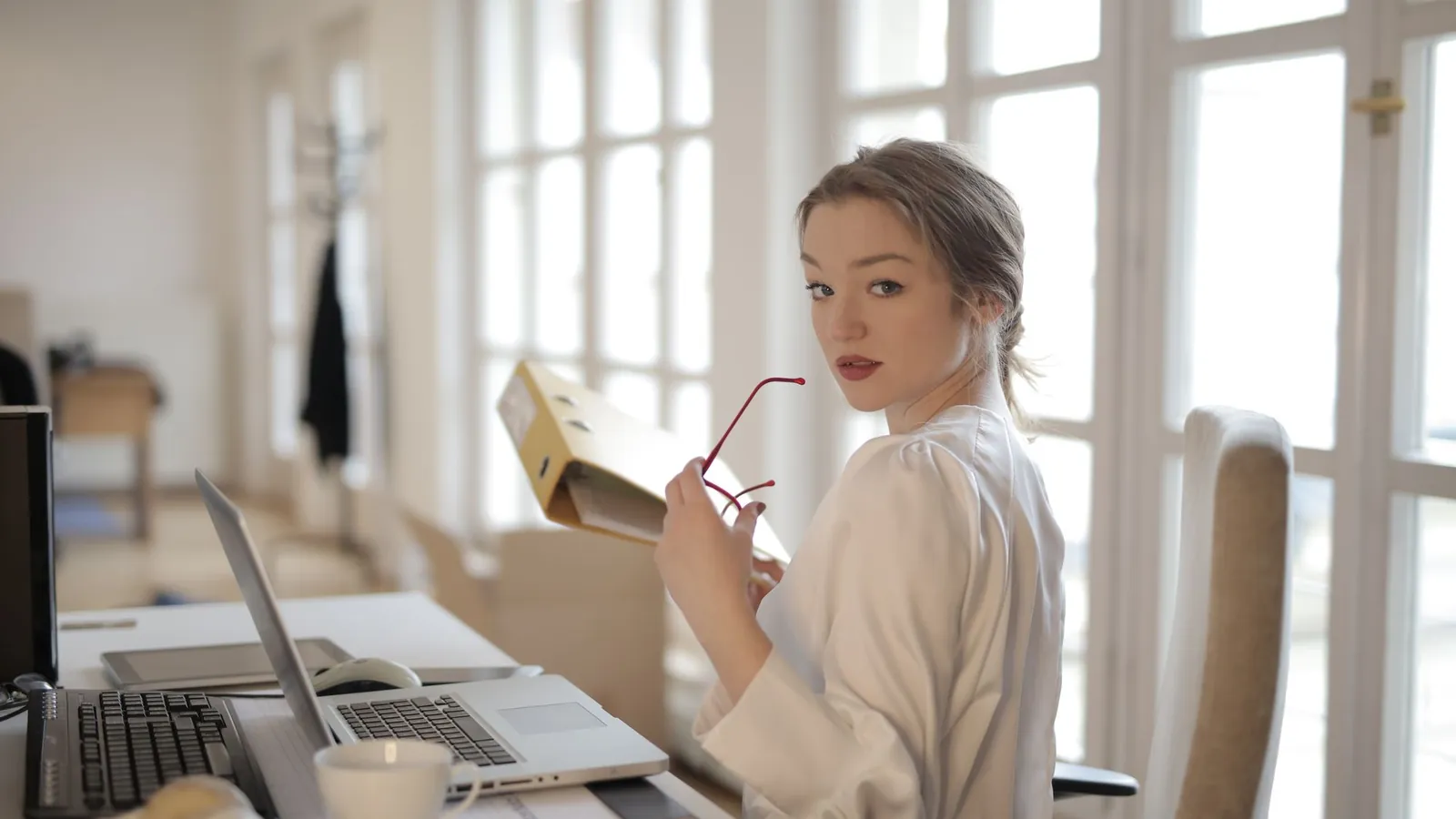 Clinic owner working through paperwork at a table in a modern workspace