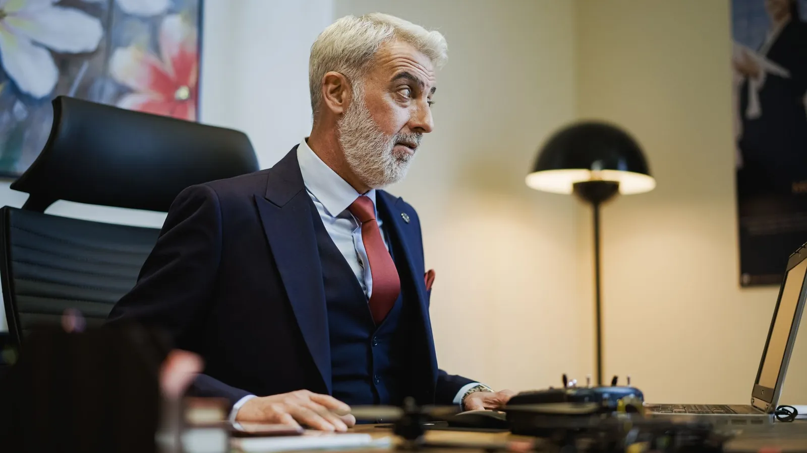 Silver-haired executive working at a desk in a modern private office