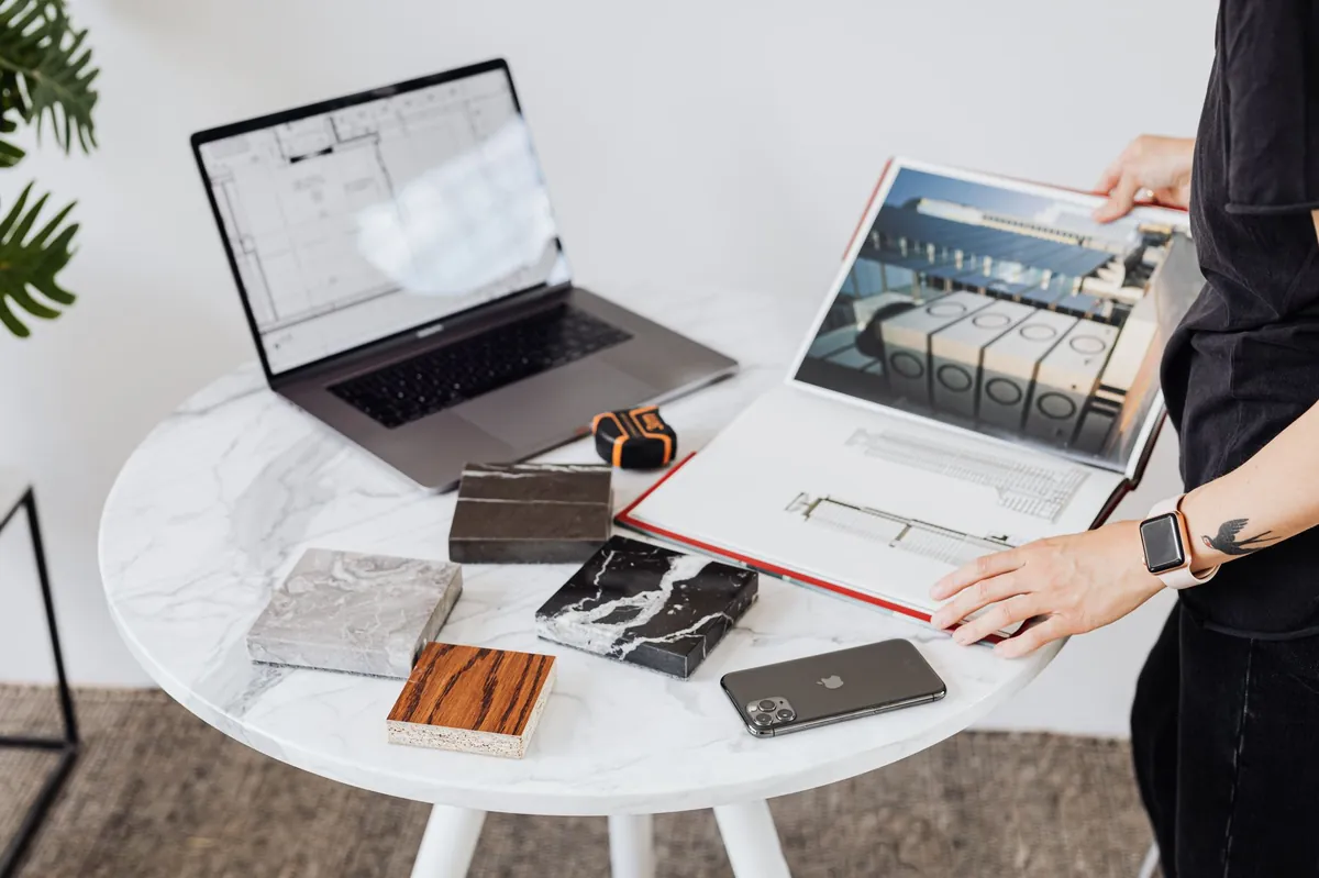 Laptop and printed brochures on a round white table during a planning session
