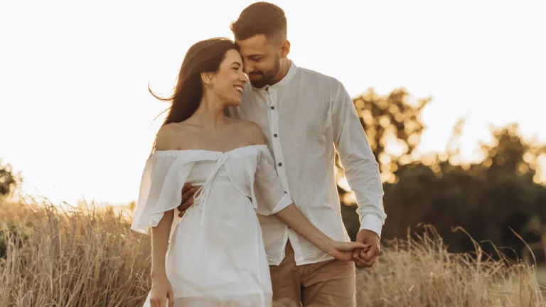 Couple in white embracing in a sunlit golden field